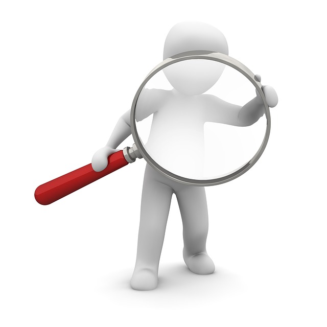 Small figure examining something through a magnifying glass