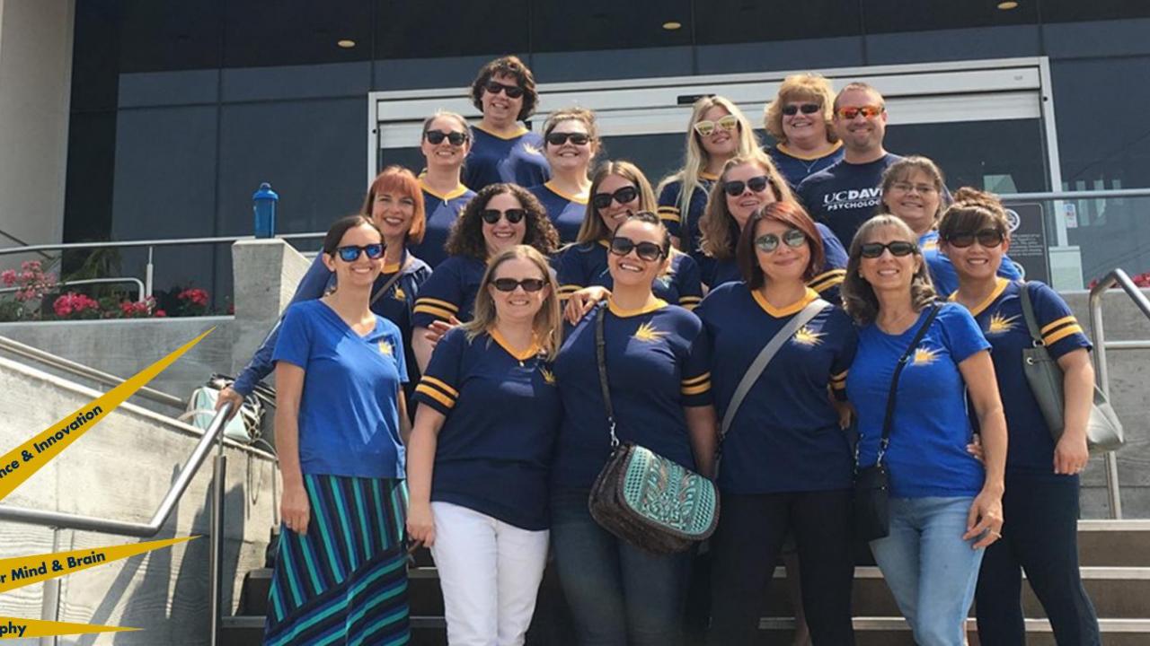Yellow Cluster staff posing together on a staircase leading up to a building.