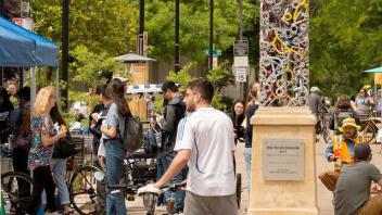 Student walking his bike through downtown Davis