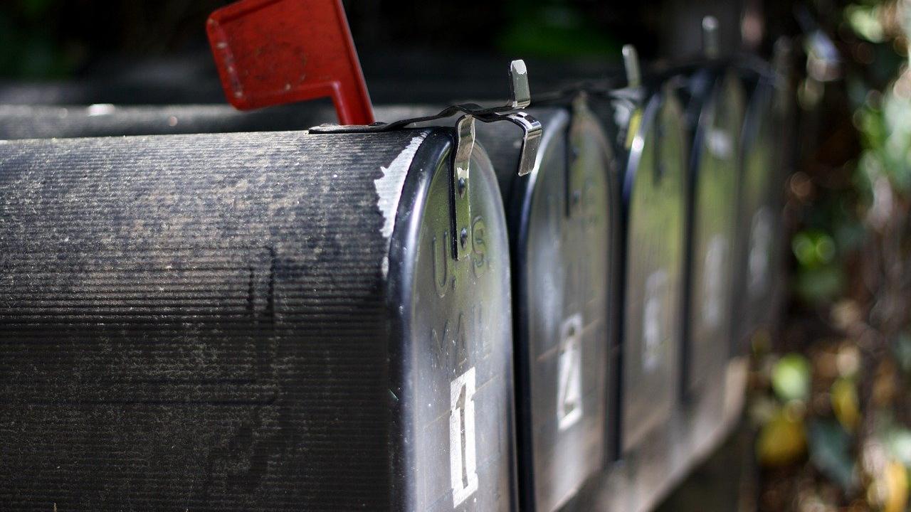A series of mailboxes, the first one with its flag set in the up position.