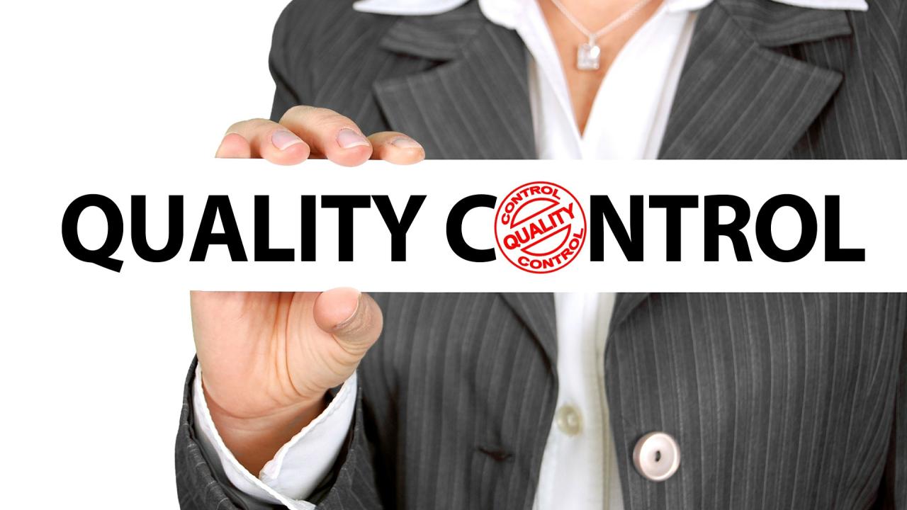 A business woman holds a sign reading Quality Control