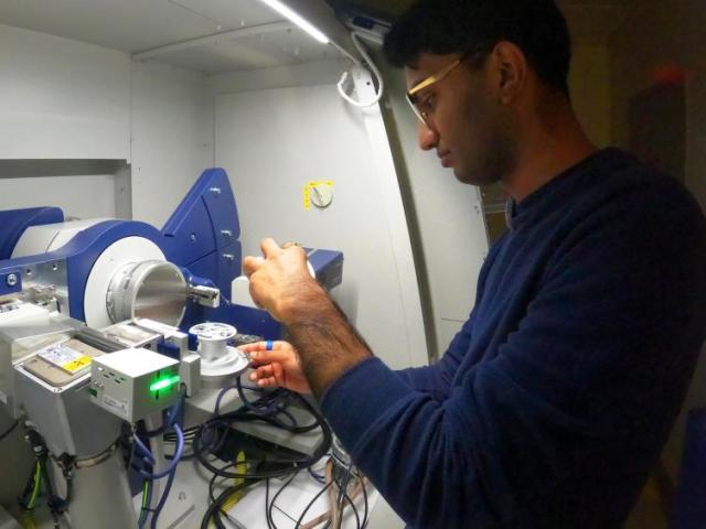 A researcher working with a piece of lab equipment.