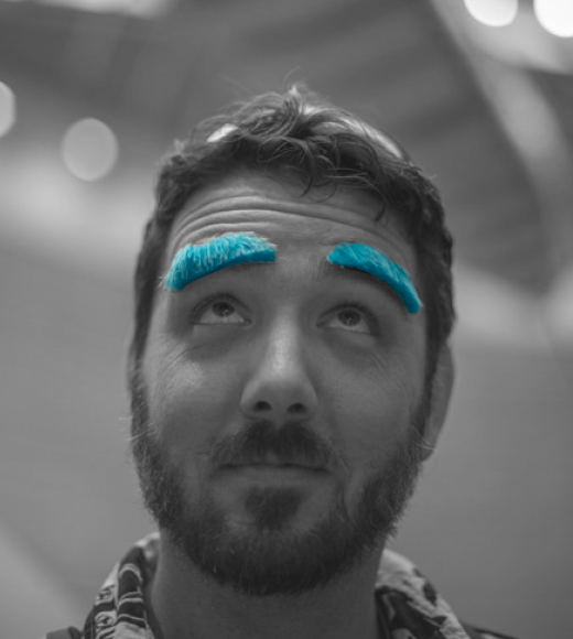 Dusty Boeger in black and white photography with thick blue comical eyebrows.