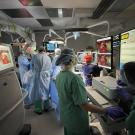 An operating room filled with medical personnel with highly technical equipment and screens.
