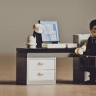 Lego figure sitting at a desk with a look of despair on his face.