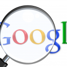 The Google logo with a magnifying glass in front of it.