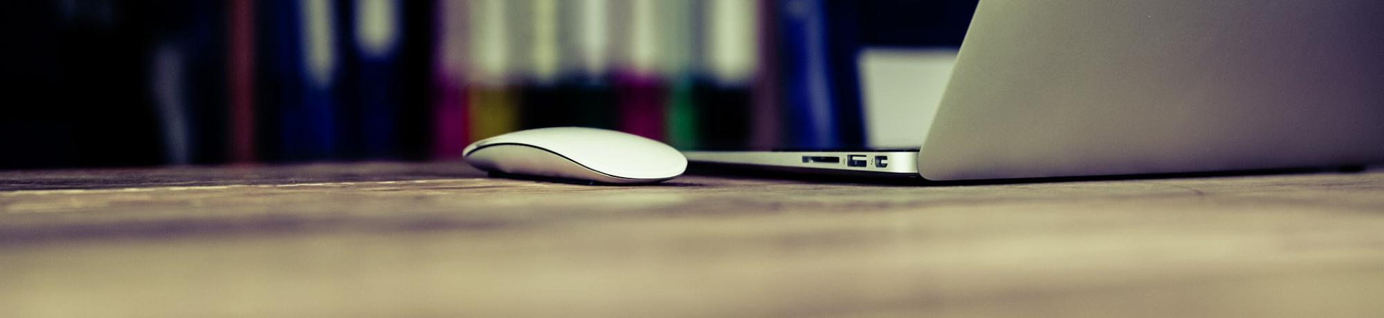 a distant view of a mouse device sitting next to a laptop